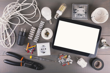 blank digital tablet with electrical tools and equipment on wood