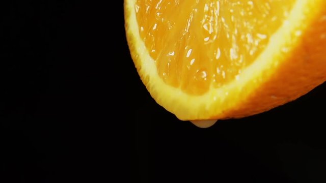 SLOW MOTION: A juice drops falls from an orange