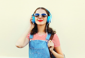 Happy woman listens to music in headphones over white background