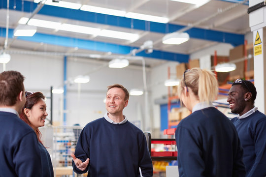 Manager explaining to team in manufacturing factory