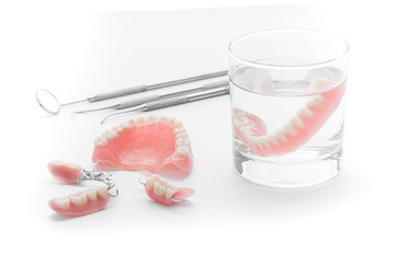 Set of Denture in glass of water and tools  on white background