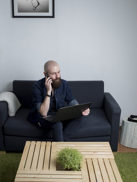 Young bearded man using a laptop at home.