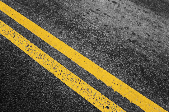 Yellow double dividing line over black highway