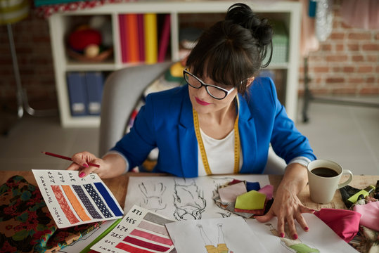 Female designer looking at color swatch - Powered by Adobe