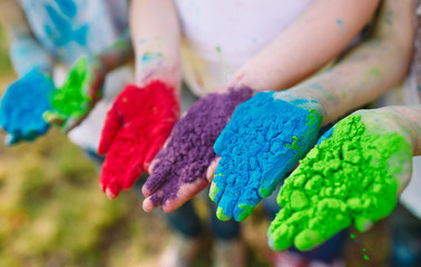 Hands / Palms of young people covered in purple, yellow, red, bl