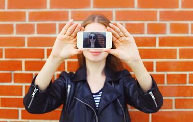 Fashion woman makes self portrait on smartphone view of screen o