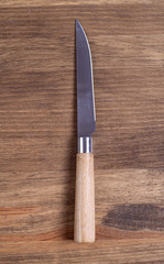 Knife with wooden handle on brown wooden table