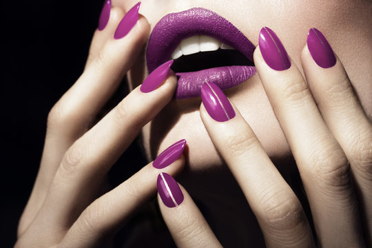 Detail of woman's mouth and hands wearing purple lipstick and nail varnish