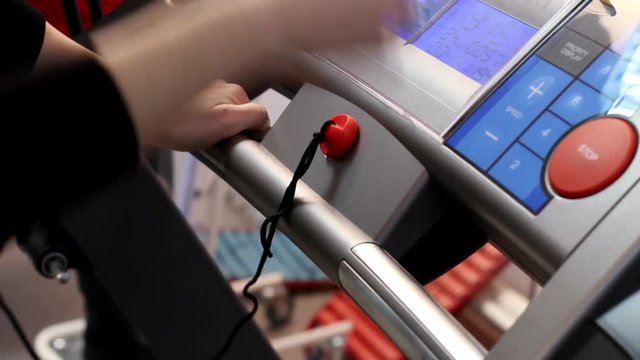 Woman exercising and running on treadmill in sport gym