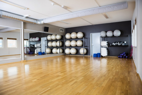 Exercise Balls Arranged In Shelves By Mirror