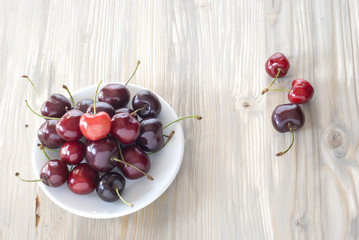 cherries on the plate, aged wood