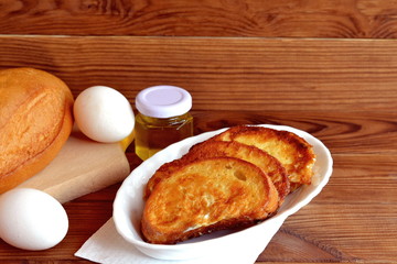 Home fried bread croutons. Fried bread with egg breakfast. Simple make roasted bread. Quick appetizer recipe. Ingredients for cooking breakfast. Wooden background with empty space for text