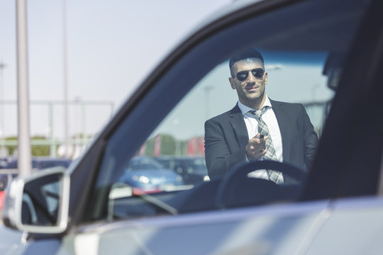 Businessman at car park opening car