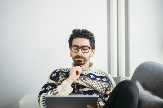 Portrait of pensive man looking at digital tablet
