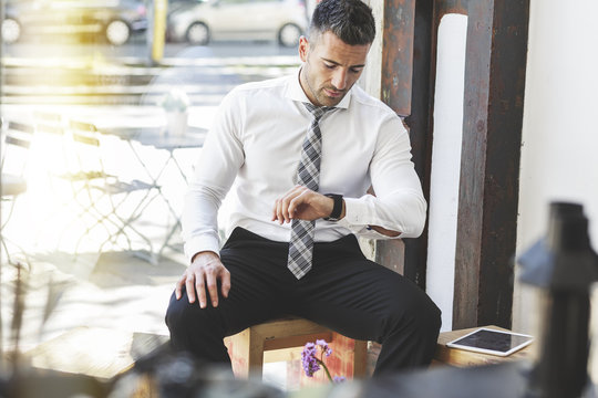 Businessman in a cafe checking the time