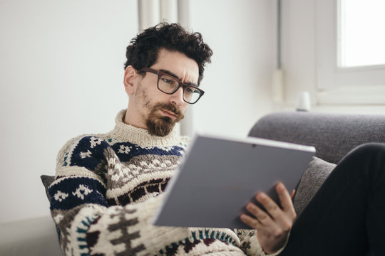 Portrait of pensive man using digital tablet