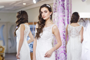 Female trying on wedding dress in a shop.