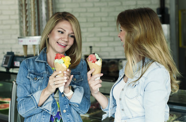 Two Beautiful young woman eating an italian ice cream