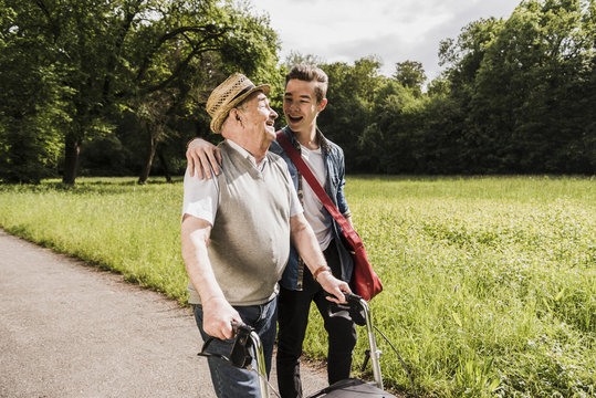 Happy grandfather walking with his grandson in nature