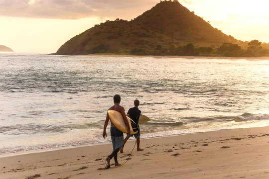 Indonesia, Sumbawa island, Surfer on a beach in the evening