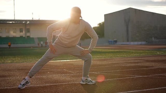 Young athletic man doing warm-up before exercise and jogging