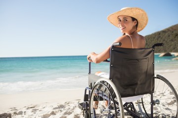  Wheelchair woman sitting smiling at camera on the beach