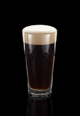 Glass of dark beer over black background