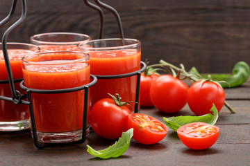 Tomato juice with vegetables on wooden background