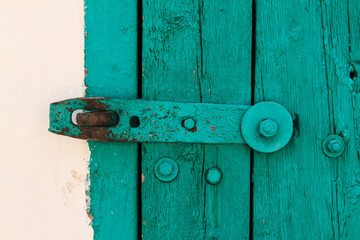 The Part of Aquamarine Old Vintage Door with Crack Paint and Big Steel Bolt on the White Wool,Texture,Background