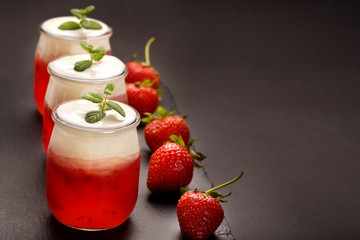 Tasty strawberry dessert in a jar on wooden background