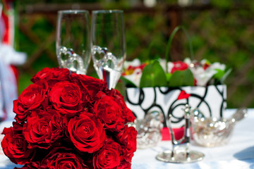 bouquet of red roses on a background of wedding accessories