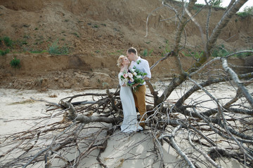 young couple; bride; groom; at the sand shore; married couple; s