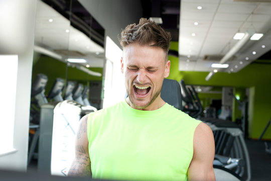 Man At Gym Exercising, Straining, Pulling Face