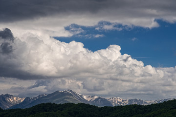 Mountain ridge with snow and blue sky with spectacular clouds in Epirus, Greece