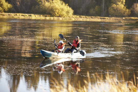 Mother and daughter kayaking together on a lake, front view