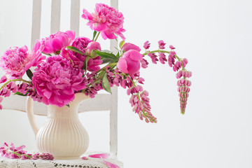 Peony flowers in a  vase on vintage chair