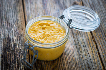 Homemade creamy peanut butter on wooden background