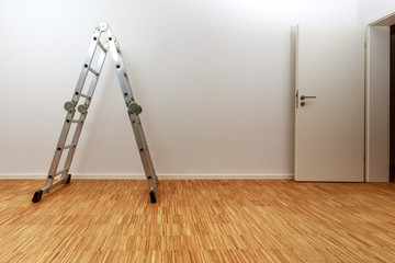 Aluminium Leiter in leerer Wohnung mit Holzparkett