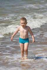 the little boy frolics at the sea