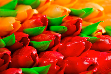Background beautiful birthday cake adorned with edible red and orange tulips