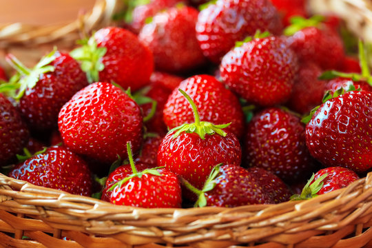 Very beautiful background with fresh strawberries in a wicker heart shaped wickerwork basket