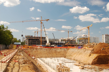 Construction cranes on a blue sky background