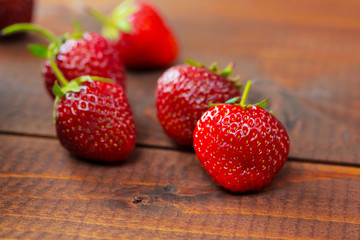 Very beautiful background with fresh strawberries in a wicker round osier basket on old brown wooden background