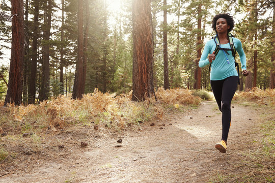 African American ethnicity woman running in a forest