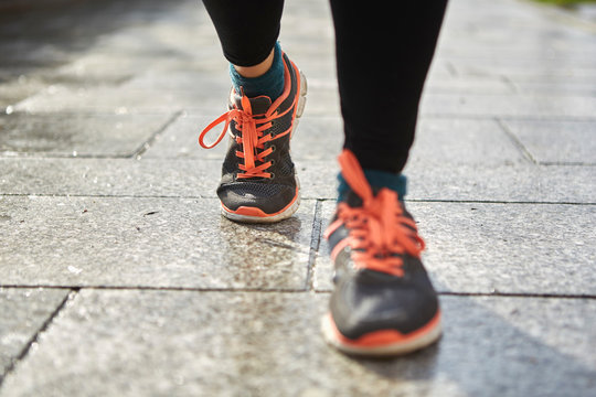 Legs Of Woman Wearing Running Shoes On Pavement