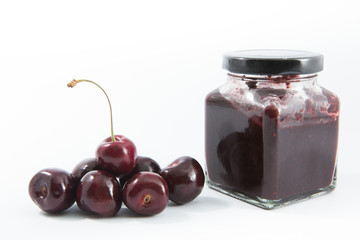 Cherry jam with fresh cherries on white background