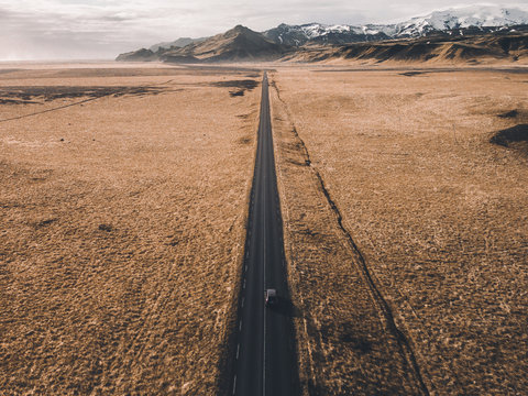 The only road - Single road leading to mountains through a surreal landscape.