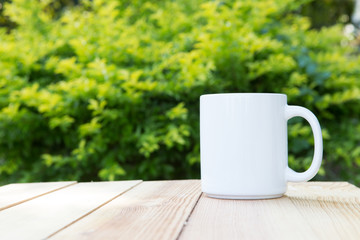 cup of coffee on table in  green tree background