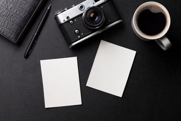 Office desk with photos, camera, coffee and notepad