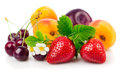 Fresh fruits and berries in still life with green leaves